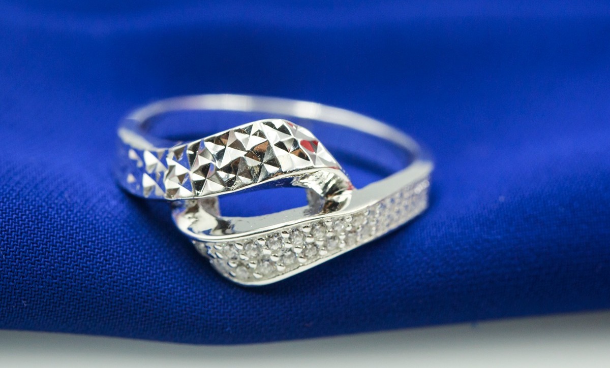Nhẫn bạc Opal V19 có thiết kế lạ mắt với mặt nhẫn là hai đường bạc xoắn gắn vào nhau, kết hợp cùng viên đá tấm nạm trên dải bạc. Đường bạc còn lại được gia công tỉ mỉ tạo sự tương phản. Nhẫn có giá 330.000 đồng, giảm 40% so với giá gốc.