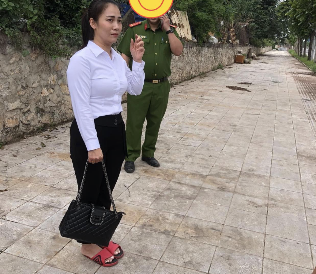Chị Hằng đứng chờ người thân đến đưa về sau màn rượt đuổi tên cướp điện thoại trên đê Ngọc Thụy (quận Long Biên), trưa 12/5. Ảnh: Varia Vu